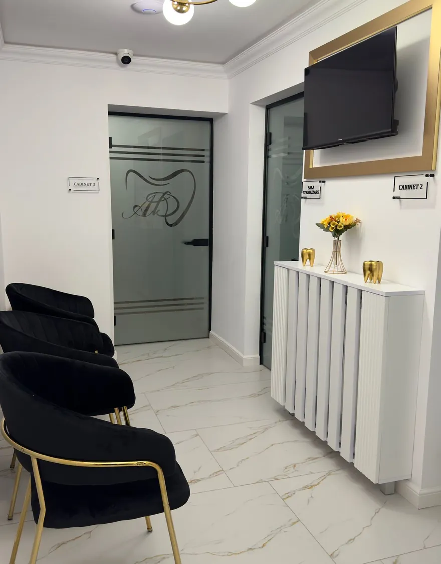 Holul clinicii: pardoseală de marmură albă cu vinișoare aurii, scaune negre de catifea cu picioare aurii, ușa de sticlă cu monograma AD.
