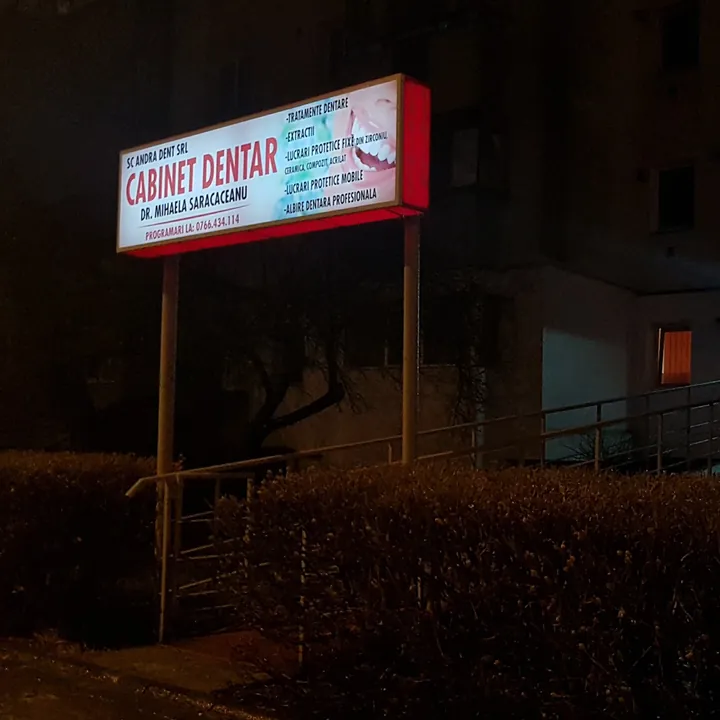 Panoul luminat al cabinetului, seara, lângă rampa de acces.