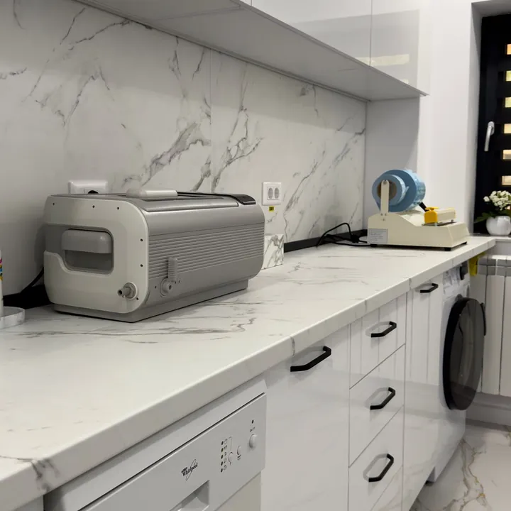 Sala de sterilizare: blat de marmură albă și aparatură de sterilizare.